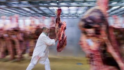 Un boucher transfère une carcasse de vache dans un entrepôt des halles de Rungis (17-12-2012). (AFP - MARTIN BUREAU)