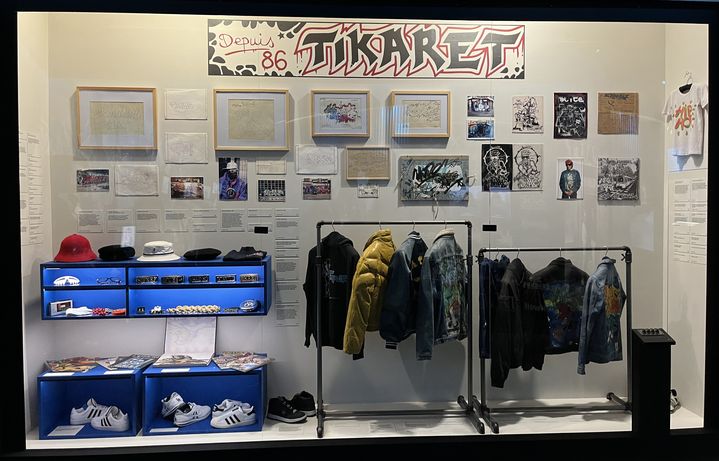 La vitrine de la boutique Ticaret (qui s'orthographie aussi Tikaret, qui signifie "commerce" en turc), avec ses blousons graffés, ses bonnet Kangol, ses nameplates (ceintures), lunettes, et autres "fat laces" (lacets épais), attributs des premiers B-Boys et B-Girls. (LAURE NARLIAN / FRANCEINFO)