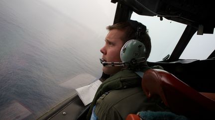 Un officier australien survole l'oc&eacute;an Indien, le 24 mars 2014, &agrave; la recherche de d&eacute;bris du Boeing disparu de la Malaysia Airlines.&nbsp; (RICHARD WAINWRIGHT / AFP)