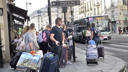 Des personnes transportent des valises dans le quartier du Marais, à Paris, le 19 octobre 2019.&nbsp; (SERGE ATTAL / AFP)