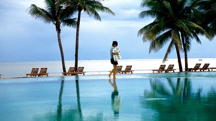 Un employé installe des serviettes près d'une piscine dans un hôtel au bord d'une plage à Pranburi (Thaïlande). (LEISA TYLER / LIGHTROCKET via GETTYIMAGES)