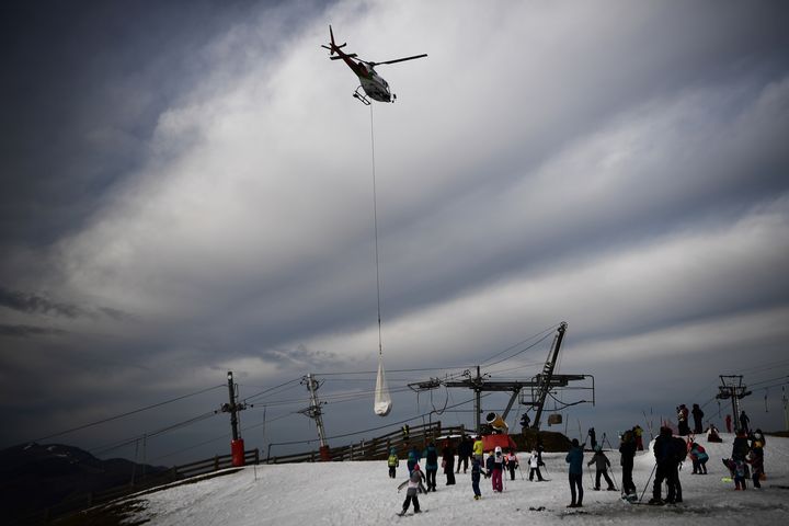 Un hélicoptère dépose de la neige, le 15 février 2020 à Superbagnères (Haute-Garonne). (ANNE-CHRISTINE POUJOULAT / AFP)