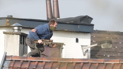 Un policier sur un toit, rue du Dries, à Forest (Bruxelles), où a&nbsp;éclaté une fusillade lors d'une perquisition, le&nbsp;15 mars 2016.&nbsp; (MAXPPP)