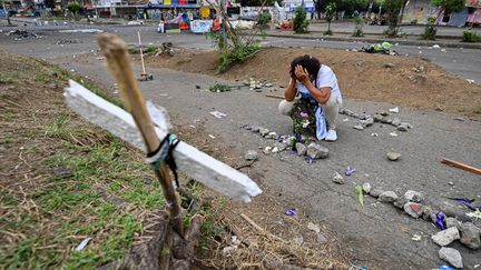 Une femme pleure la mort de manifestants lors de rassemblements contre le gouvernement du président Ivan Duque, le 29 mai 2021 à Cali (Colombie).&nbsp; (LUIS ROBAYO / AFP)