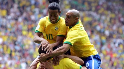 Les joueurs du Br&eacute;sil Ronaldo (de dos), Roberto Carlos (&agrave; droite)&nbsp;et Ronaldinho c&eacute;l&egrave;brent un but lors de leur 8e de finale contre le Ghana, &agrave; Dortmund (Allemagne), le 27 juin 2006.&nbsp; (MEXSPORT / AFP)