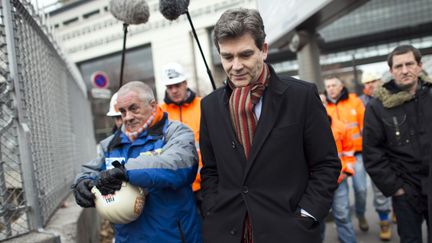 Le ministre du Redressement productif, Arnaud Montebourg, le 30 novembre 2012, &agrave; Paris, avec des employ&eacute;s d'ArcellorMittal. (FRED DUFOUR / AFP)