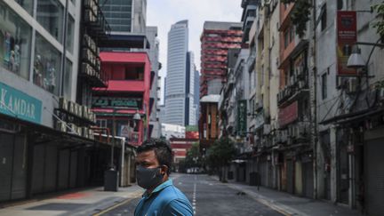 Un homme marche dans une rue vide, à Kuala Lumpur (Malaisie), le 2 avril 2020. (FAZRY ISMAIL / EPA)