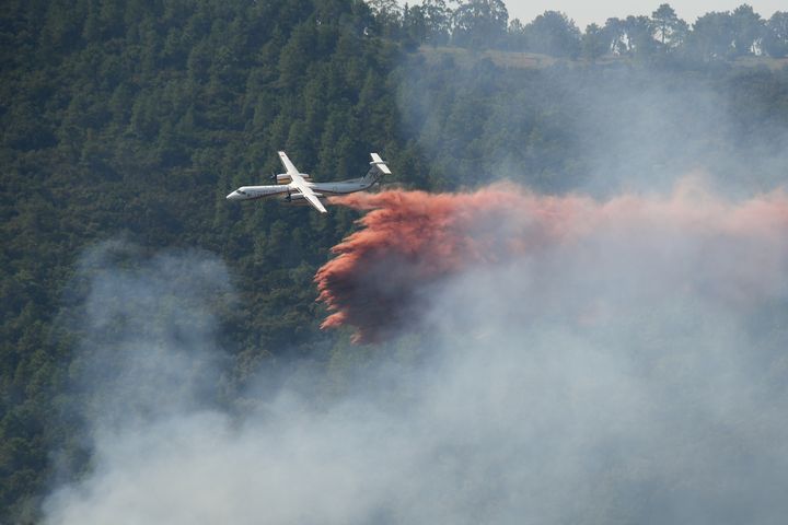 Un avion Bombardier Dash de la Sécurité Civile tente d'empêcher la propagation d'un feu de forêt près de Grimaud dans le Var, le 18 août 2021. (NICOLAS TUCAT / AFP)