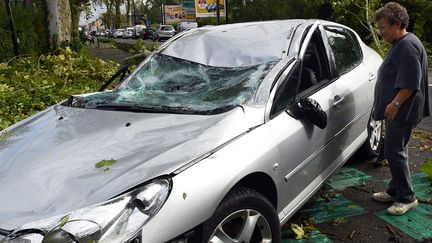 Un habitant de Montech (Tarn-et-Garonne)&nbsp;d&eacute;couvre sa voiture &eacute;cras&eacute;e par un arbre, le 1er septembre 2015. (MAXPPP)