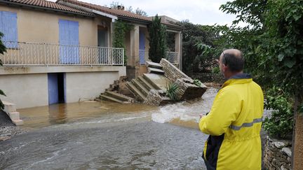 Un homme observe sa maison, &agrave; N&icirc;mes, le 10 octobre 2014. (BORIS HORVAT / AFP)