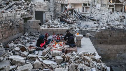 Une famille dans les ruines de sa maison à Ariya, près d'Idlib en Syrie, le 4 mai 2020 (AAREF WATAD / AFP)