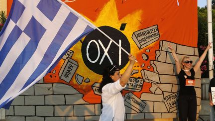 Une femme brandit un drapeau grec devant le slogan du "non" au r&eacute;f&eacute;rendum, "oxi", &agrave; Ath&egrave;nes (Gr&egrave;ce), le 10 juillet 2013. (PETROS KARADJIAS/AP/SIPA / AP)