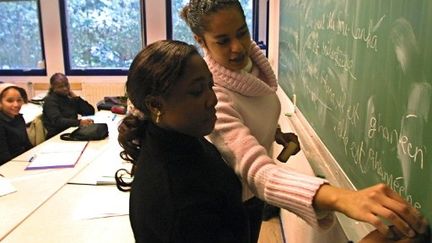 Un professeur de français corrige l'exercice d'une de ses élèves au lycée Le Corbusier d'Illkirch-Graffenstaden (2001). (AFP - Thomas Wirth)