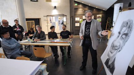 Philippe Moine explique aux visiteurs son dessin, lors de la première édition des Journées du dessin de presse et de la Caricature à Bayonne, avril 2015
 (IROZ GAIZKA / AFP)