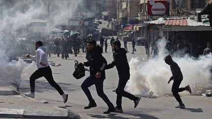 Des Palestiniens fuient des tirs de gaz lacrymogène dans la ville de Naplouse, en Cisjordanie occupée, le 22 février 2023. (ZAIN JAAFAR / AFP)