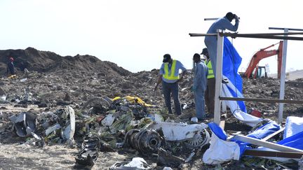 Des hommes se trouvent près de l'épave de l'avion qui s'est crashé le 10 mars dernier en Ethiopie.&nbsp; (STRINGER / EPA)