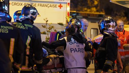 Les secours évacuent des victimes de l'attaque perpétrée devant le restaurant Le Petit Cambodge, le 14 novembre 2015 à Paris. (MUSTAFA YALCIN / ANADOLU AGENCY / AFP)