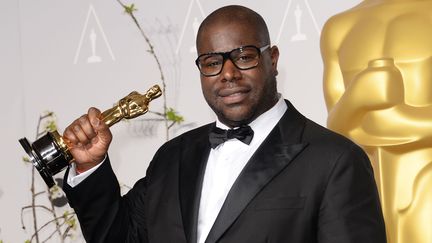 Le réalisateur britannique Steve McQueen brandit l'Oscar du meilleur film obtenu pour&nbsp;son film "Twelve Years a Slave", le 2 mars 2014 à Hollywood (Etats-Unis). (JASON MERRITT / GETTY IMAGES NORTH AMERICA / AFP)