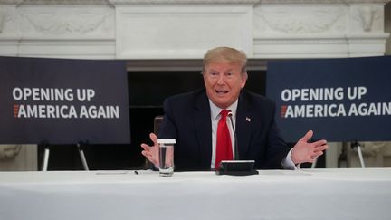 Le président Donald Trump lors d'une réunion avec les chefs d'industrie américains à la Maison Blanche, devant des panneaux "Rouvrir l'Amérique", le 29 mai 2020. (JONATHAN ERNST / X90178)