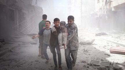 Toujours dans le quartier de Sukkeri, cet enfant blessé est secouru par les habitants. (OMAR ARAB / ANADOLU AGENCY / AFP)