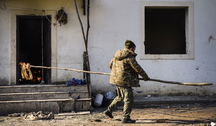 Un habitant du village de&nbsp;Charektar, dans la région du Haut-Karabakh, brûle sa maison, le 14 novembre 2020. (ALEXANDER NEMENOV / AFP)