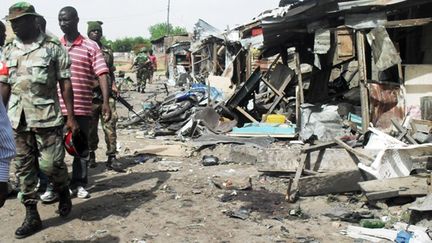 Des soldats marchent dans le march&eacute; de Bauchi, au Nigeria, apr&egrave;s une attaque terroriste, le 30 mai 2011. (AMINU ABUBAKAR / AFP)