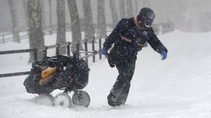 Le froid n'a pas arrêté cette factrice new-yorkaise, qui a traîné son chariot de courrier dans les rues enneigées de Brooklyn. (ANGELA WEISS / AFP)