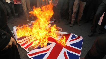 Des Iraniens br&ucirc;lent le drapeau britannique devant l'ambassade de Grande-Bretagne &agrave; T&eacute;h&eacute;ran en Iran le 29 novembre 2011.&nbsp; (ATTA KENARE / AFP)