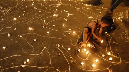 Un jeune gar&ccedil;on allume des bougies &agrave; Manille (Philippines) lors de la c&eacute;r&eacute;monie comm&eacute;morative du 2e anniversaire du massacre de 57 personnes dans le sud du pays, le 23 novembre 2011. (BULLIT MARQUEZ / AP / SIPA)