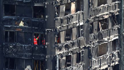 Des secouristes à l'intérieur de la tour Grenfell, dans le quartier de North Kensington, à Londres, dimanche 18 juin 2017.&nbsp; (NEIL HALL / REUTERS)