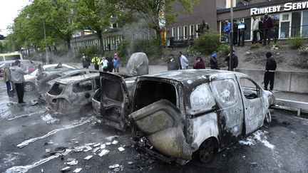 Des voitures br&ucirc;l&eacute;es dans la banlieue de&nbsp;Stockholm, &agrave; Rinkeby (Su&egrave;de), le 24 mai 2013. (JONATHAN NACKSTRAND / AFP)