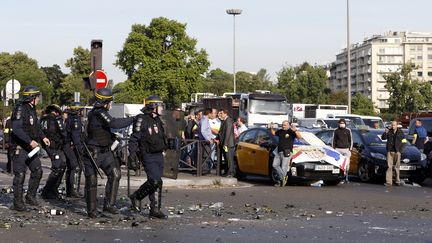 Des CRS interviennent lors d'une manifestation de chauffeurs de taxi, porte Maillot, &agrave; Paris, le 25 juin 2015. (THOMAS SAMSON / AFP)