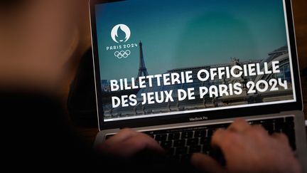 Un homme consulte le site web de la billetterie de Paris 2024, le 20 mars 2023. (LOIC VENANCE / AFP)