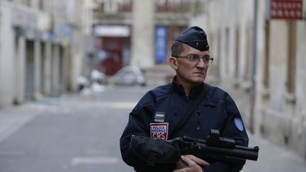 Un policier français surveille l'entrée d'une rue de Saint Denis le 19 novembre 2015.