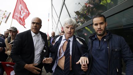 L'un des dirigeants d'Air France, Pierre Plissionnier, est exfiltr&eacute; du si&egrave;ge d'Air France, le 5 octobre 2015 &agrave; Roissy. (KENZO TRIBOUILLARD / AFP)