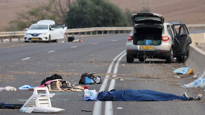 Un corps gît sur une route israélienne près du kibboutz Gevim, à proximité de la frontière avec la bande de Gaza, le 7 octobre 2023. (OREN ZIV / AFP)