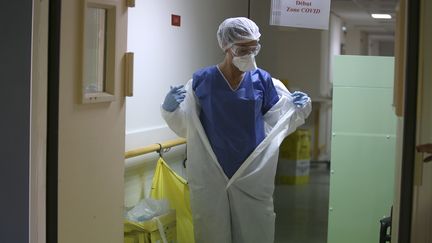 Une infirmière enfile une tenue de protection à l'entrée de la "zone Covid" de l'hôpital Eugénie d'Ajaccio (Corse-du-Sud), le 23 avril 2020. (PASCAL POCHARD-CASABIANCA / AFP)