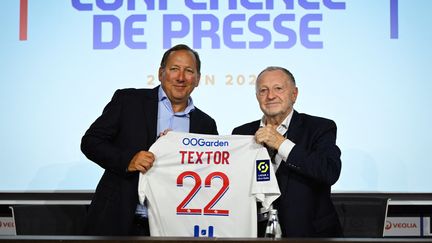 L'homme d'affaires américain et actionnaire majoritaire d'Eagle Football, John Textor, en compagnie du président de l'OL, Jean-Michel Aulas, lors d'une conférence de presse, le 21 juin 2022. (OLIVIER CHASSIGNOLE / AFP)