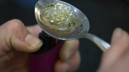 Une toxicomane fait bouillir une portion de crack dans une cuillère, le 19 novembre 2019, à Francfort (Allemagne). Image d'illustration. (BORIS ROESSLER / DPA / AFP)