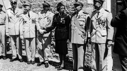 La chanteuse et danseuse Joséphine Baker entourée d'officiers de l'armée française durant la cérémonie où elle a reçu la Légion d'honneur et la Croix de guerre, le 19 août 1961, au château des Milandes (Dordogne). (AFP)