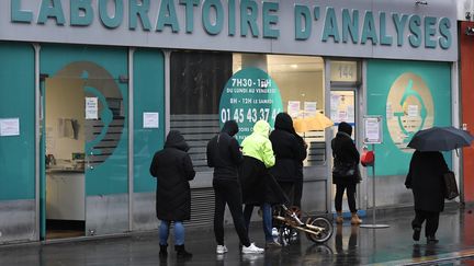 La file d'attente devant un laboratoire d'analyses médicales à Paris, le 22 décembre 2020. (STEPHANE DE SAKUTIN / AFP)