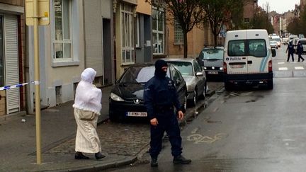 Une riveraine tente de rentrer chez elle, à Molenbeek (Bruxelles), juste après l'intervention policière, lundi 16 novembre 2015. (KOCILA MAKDECHE / FRANCETV INFO)