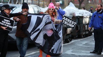 Une femme porte une pancarte "Arrêtez Trump", le 30 mars 2023, à New York. (SPENCER PLATT / GETTY IMAGES NORTH AMERICA)