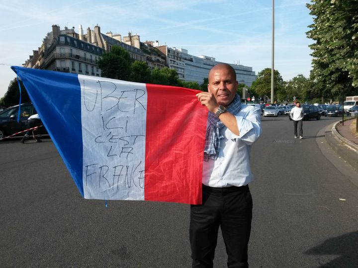 Un chauffeur de taxi accuse la firme am&eacute;ricaine Uber de "marcher sur le syst&egrave;me fran&ccedil;ais" et de ne pas payer d'imp&ocirc;ts, le 25 juin 2015 &agrave; Paris. (JEROMINE SANTO-GAMMAIRE / FRANCETV INFO)