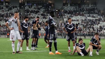 Les joueurs bordelais sur la pelouse du Matmut Atlantique après la décision de l'arbitre d'arrêter le match contre Rodez, le 2 juin 2023. (THIBAUD MORITZ / AFP)