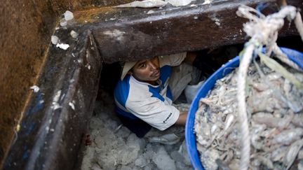 Un homme originaire du Cambodge travaille sur un bateau de p&ecirc;che, le 25 f&eacute;vrier 2010, pr&egrave;s de Bangkok (Tha&iuml;lande). (NICOLAS ASFOURI / AFP)