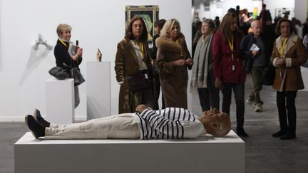 Des visiteurs regardent une sculpture représentant l'artiste Pablo Picasso à l'Arco de Madrid, le 23 février 2023. (PIERRE-PHILIPPE MARCOU / AFP)