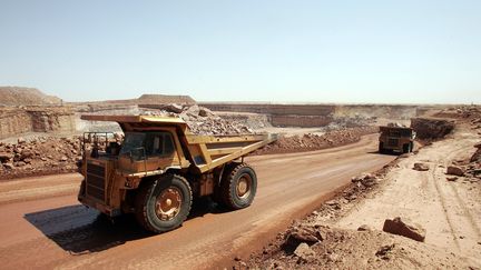 Des camions de la Somaïr (société des mines de l'Aïr) transportent de la roche contenant de l'uranium de la mine à ciel ouvert d'Arlit (Niger), dans le désert de l'Aïr, le 23 février 2005.&nbsp; (PIERRE VERDY / AFP)