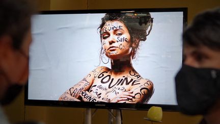 Des festivaliers devant un écran diffusant la campagne de préventions des violences "Ici c'est cool" au Printemps de Bourges, le 23 juin 2021. (GUILLAUME SOUVANT / AFP)