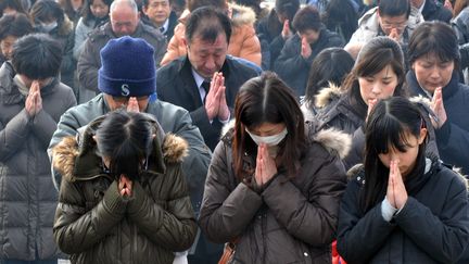 Dans les villes et villages japonais d&eacute;vast&eacute;s, les proches des quelque 19.000 morts et disparus se sont recueillis dans le chagrin et la douleur, au cours de c&eacute;r&eacute;monies improvis&eacute;es sur les lieux de la trag&eacute;die. (KAZUHIRO NOGI / AFP)